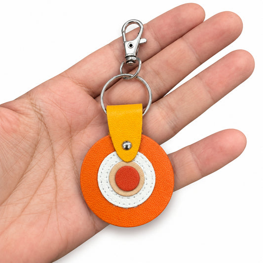 Porte-clés / bijou de sac rond en cuir orange