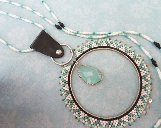 Long necklace with a large woven ring pendant and an aqua faceted bead