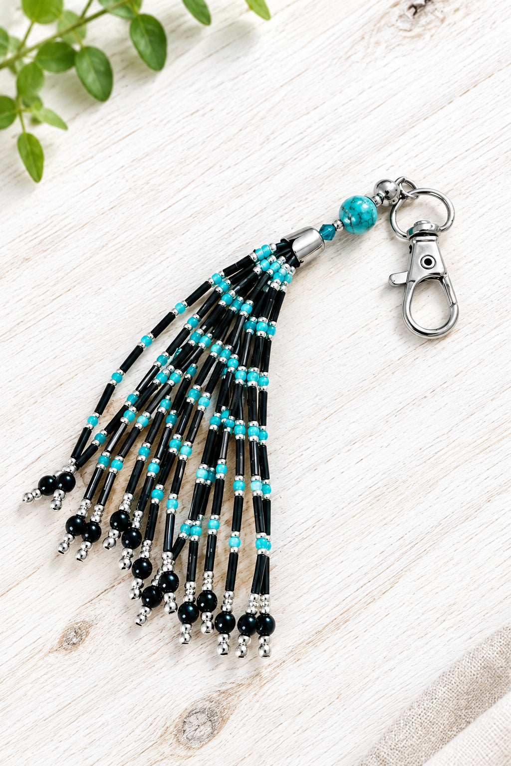 Porte-clés / bijou de sac en perles turquoise, noires et argentées