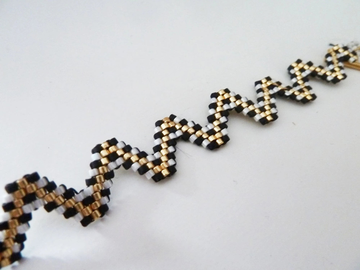 Bracelet tissé forme zig zag noir écru doré inspiration bohème graphique