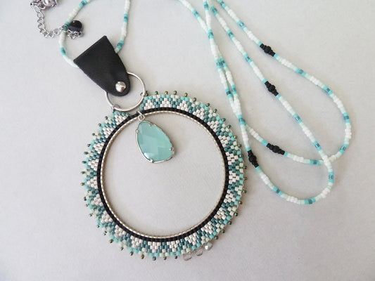 Long necklace with a large woven ring pendant and an aqua faceted bead